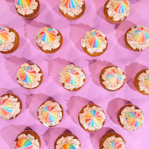 Unicorn Cupcakes from Crumbs & Doilies with rainbow Swiss meringue buttercream and sprinkles on pink background